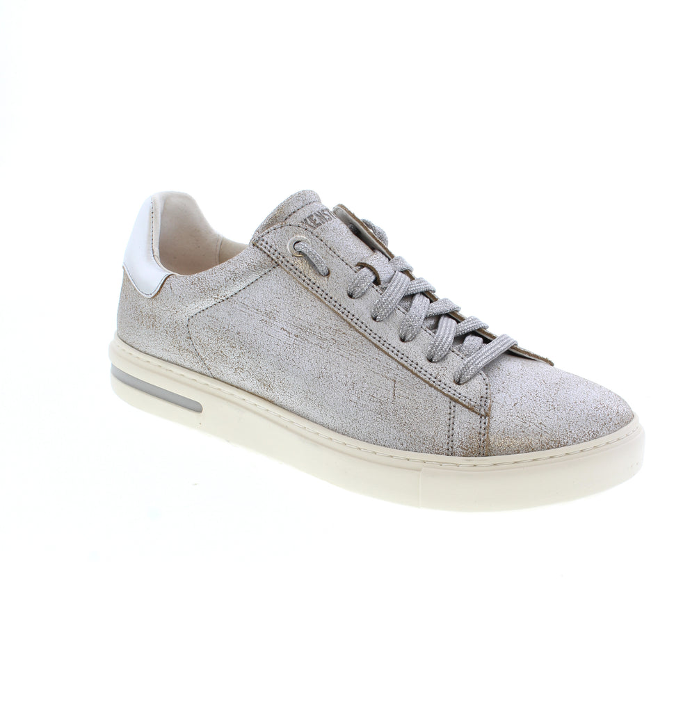 Elevate your everyday style with the Birkenstock Bend Low in striking metallic silver. This athleisure sneaker combines sleek design with Birkenstock's legendary comfort, featuring a supportive cork midsole, orthopedic-grade arch support, and a removable suede footbed for all-day wear. Metallic leather upper with leather lining ensures durability and easy care. The hard footbed with deep heel cup and metatarsal support keeps your feet aligned and comfortable.