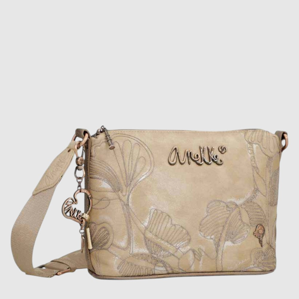 Discover the true essence of Anekke with this large-sized rectangular crossbody bag. Its floral design, shimmering sand accents, and adjustable shoulder strap will transport you to the Mediterranean with every wear. With a zip closure, lined interior, and pockets, this bag is both functional and sentimental.