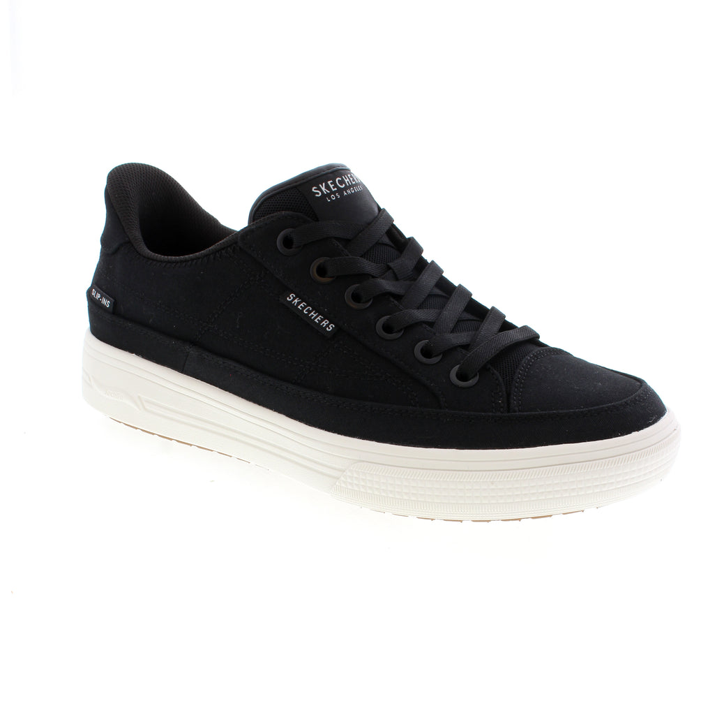 The Skechers Slip-Ins Arcade 183222-183222W-BLK sneaker in black offers easy on-and-off convenience with bungee laces and a step-in design. Built with a canvas upper, memory foam midsole, and removable microfiber insole for all-day comfort. The round toe and rubber sole provide casual durability, while the orthotic-friendly construction suits multiple widths. Perfect for athleisure and everyday wear year-round.