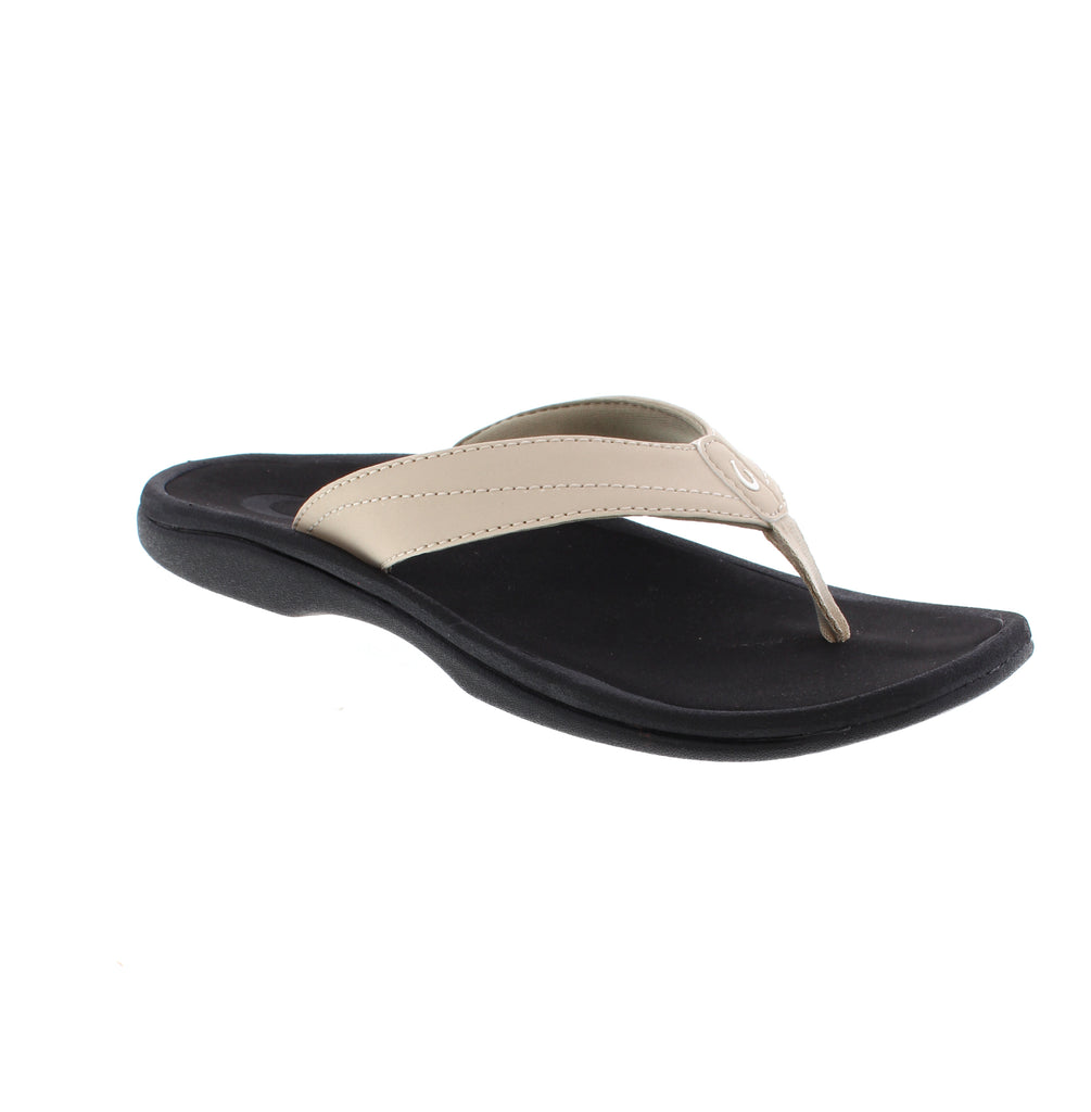 OluKai Ohana women's sandal 20110-FD40 in grey and black. Water-resistant man-made leather upper with microfiber lining. Slip-on thong style with light arch support for all-day comfort. EVA/PU midsole and footbed paired with non-marking rubber outsole. Perfect for casual summer wear.