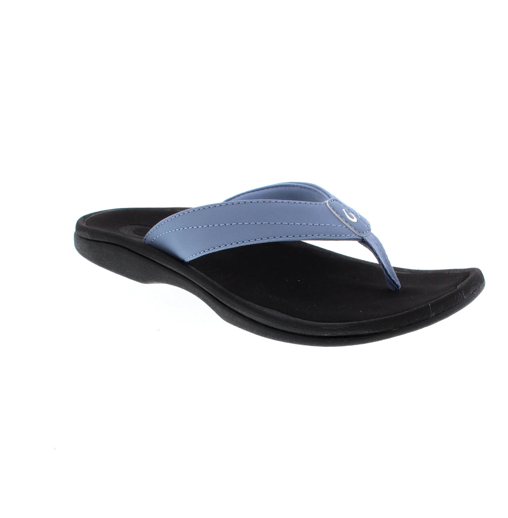 OluKai Ohana women's flip-flop 20110-FN40 in blue and black. Water-resistant man-made leather with microfiber lining. Slip-on design with light arch support for everyday comfort. EVA/PU midsole and footbed with non-marking rubber outsole. True to size fit, ideal for casual summer activities.