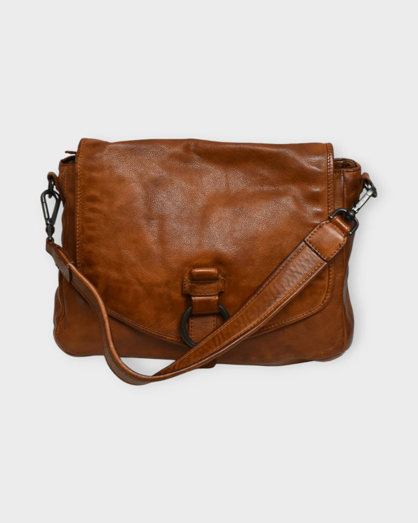Crafted in Italy from high-quality genuine leather, The Trend 22785 - Tan combines sophisticated style with practical design. Measuring 7" high, 11" wide, and 3.5–4" deep, it features a secure magnetic button flap and a main compartment with a full zip closure. Inside, organize essentials with one zippered and two open pockets, while an exterior zip pocket offers easy access to frequently used items. 