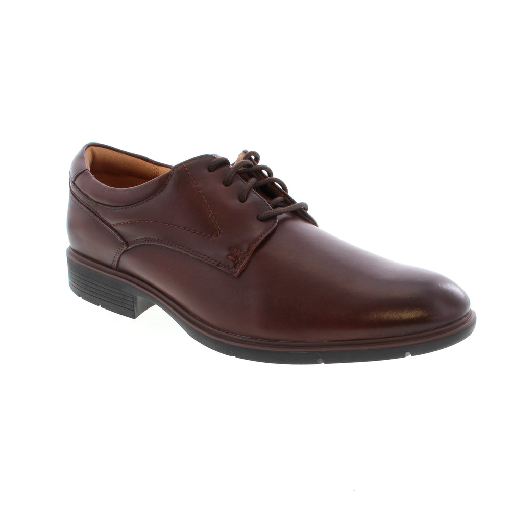 Timeless sophistication meets everyday comfort in the Clarks Eldredge Plain. This classic brown leather dress shoe features a refined plain toe design and lace-up entry, perfect for the office or formal occasions. Crafted with a premium leather upper, leather lining, and leather footbed for all-day comfort, the Eldredge delivers durability and style. The foam midsole and rubber outsole provide reliable support, while the block heel and almond toe shape offer a polished, professional look.