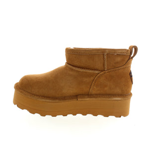 Introducing the Bearpaw Retro Shorty, a modern twist on a classic suede boots. Featuring a sheepskin wool lining for warmth, and BearCoat™ Rain & Stain Repellent for dryness. Stand out with the unique exterior detail and cropped bootie look. Stay stylish and cozy this season.