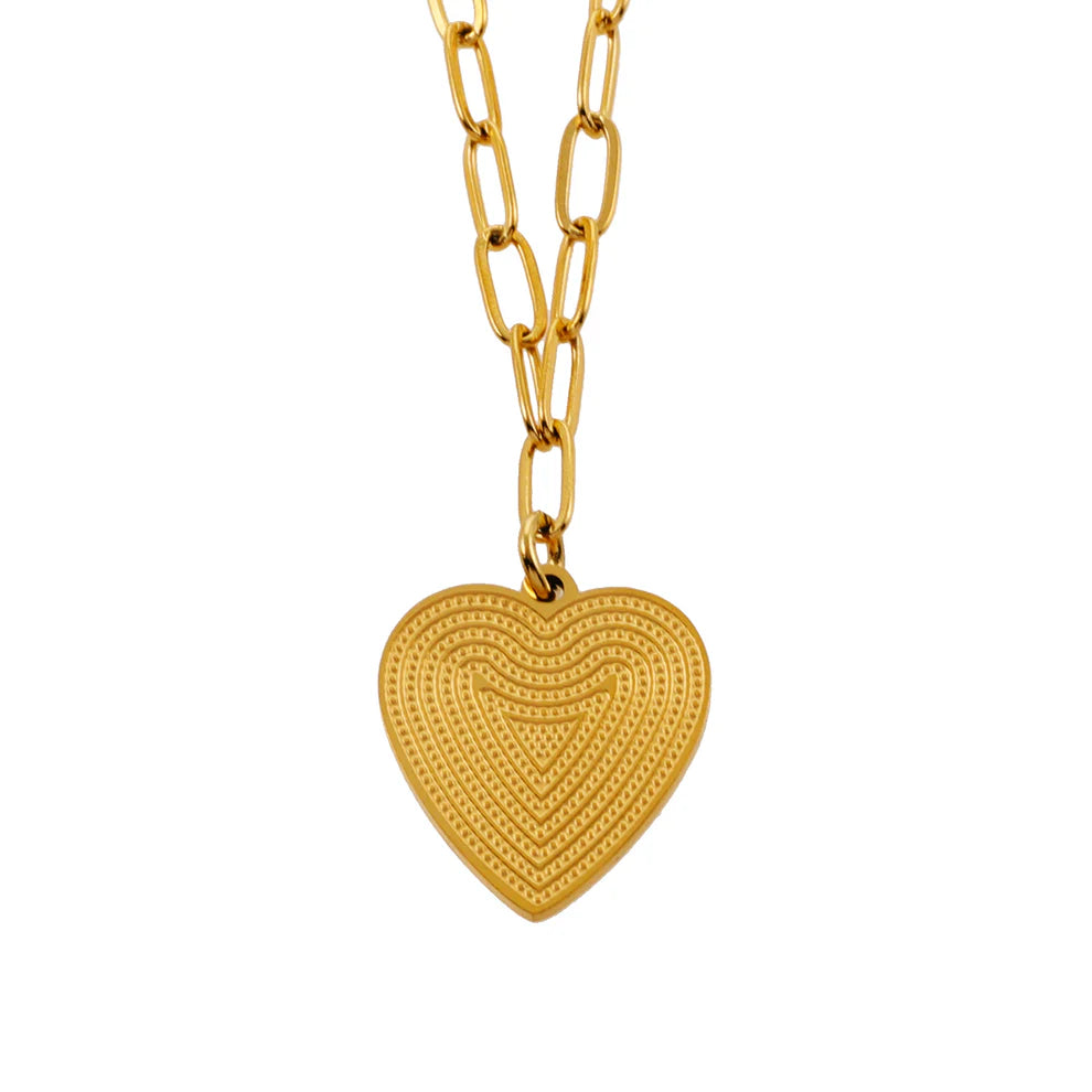 Discover modern elegance with our Hackney Nine Alara - Gold Paper Clip Chain Necklace. Meticulously crafted, this unique accessory features interconnected paper clips for a touch of contemporary flair. The intricate patterned heart charm at the center not only adds grace and style but also represents connectivity and unity. A must-have for any jewelry collection.