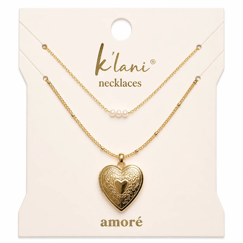 Introducing the K'lani Amore necklaces.&nbsp; A romantic necklace set in warm gold tones featuring a delicate heart locket and a dainty chain with three petite pearls. Wear together or separately for timeless elegance and meaningful moments.