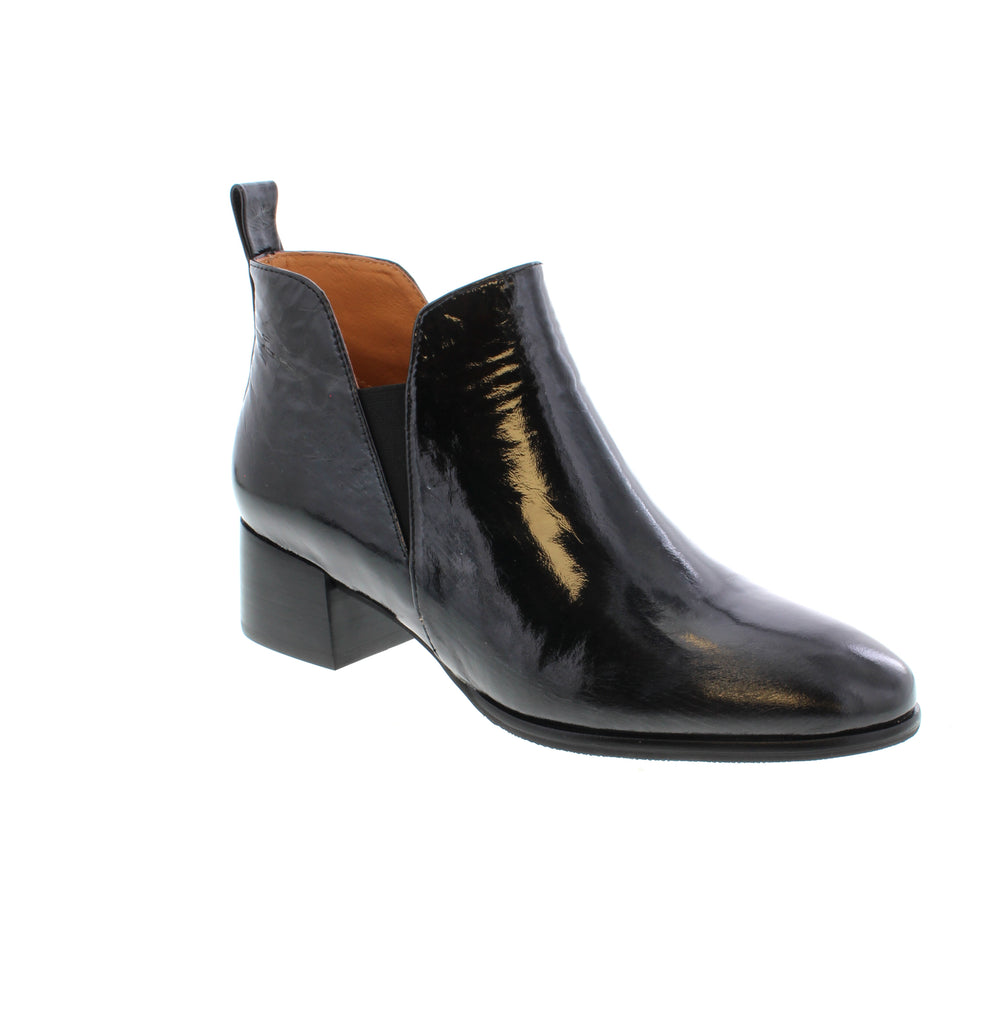 The Tamara London Anexia is a patent-leather ankle boot, featuring elastic gore panels for effortless on/off and a chunky heel for a touch of elegance.