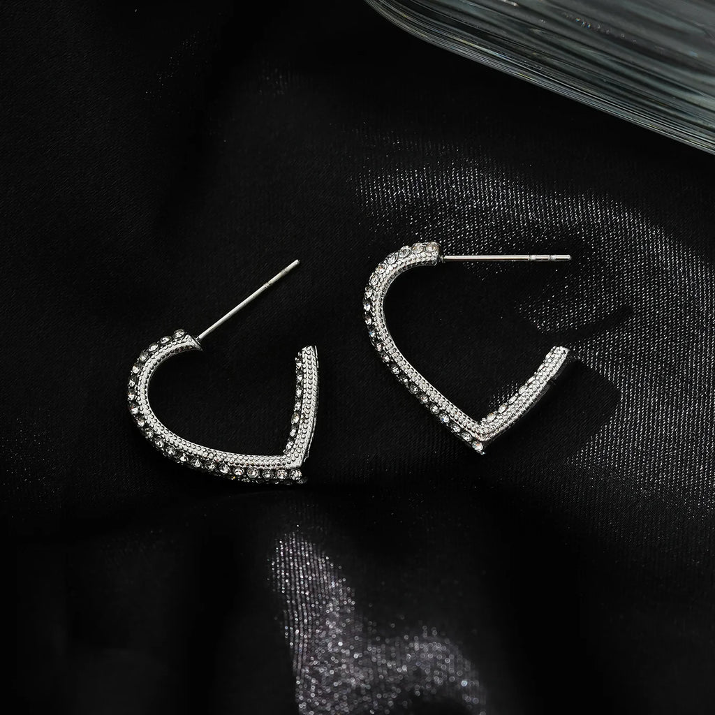 Elevate your style game with the Hackney Nine Anjar White Gold Heart Shaped Hoop Earrings. Embedded with sparkling zirconia gemstones, these earrings exude understated glamour for any occasion. As a perfect gift that symbolizes grace and sophistication, they make a great choice for birthdays, anniversaries, or any special celebration.