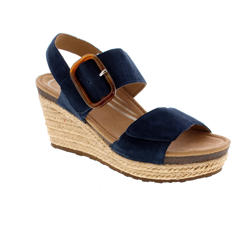 The Aetrex Ashley in Navy is a versatile summer essential designed for casual comfort and support. Featuring a genuine leather upper with a round toe silhouette, this wedge sandal rises 2-3 inches for a flattering lift. The memory foam and cork midsole work together to provide responsive cushioning and lightweight support, while the microfiber footbed is treated with odor-control and anti-bacterial technology to keep feet fresh. 