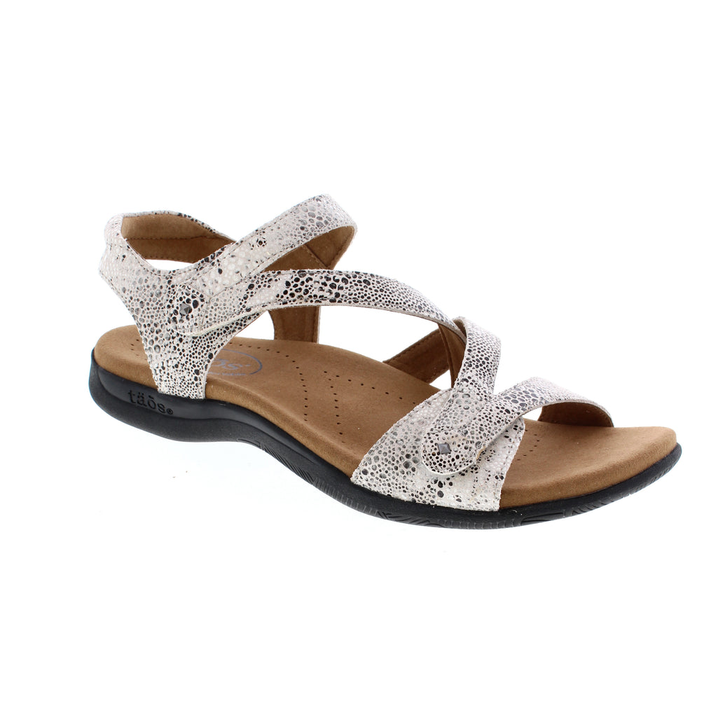 The Taos Big Time sandal in grey snake combines style with supportive comfort. Featuring a leather upper with a reptile pattern, this strappy sandal includes light arch and metatarsal support for all-day wear. The padded collar, anti-bacterial microfiber footbed, and EVA/PU midsole keep your feet cushioned and fresh. Velcro closure and rubber outsole make it perfect for casual summer adventures.