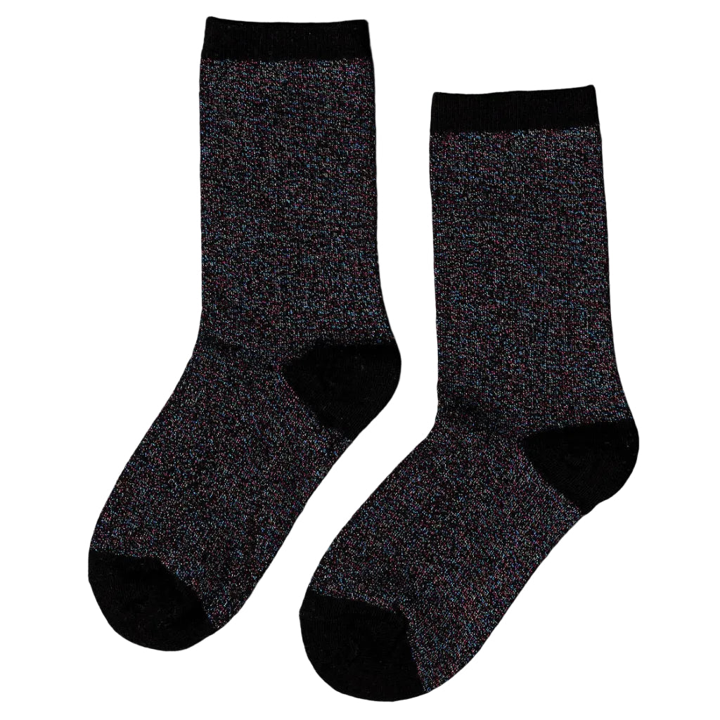Unified Glitter Socks in Black Disco deliver everyday sparkle with serious style. Crafted from a soft blend of nylon, cotton, and spandex, these socks transition seamlessly from sleek and polished under boots to relaxed and scrunched with sneakers. The subtle glitter catches light without overwhelming, making them perfect for adding unexpected shine to any look—whether you're heading to a party or just want to elevate your everyday wear. 
