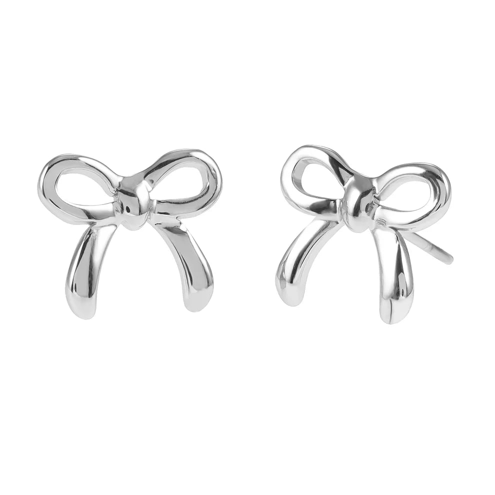 Elevate your style with our Hackney Nine Bow - White Gold earrings. Made from premium white gold, their polished silver-toned finish adds a touch of refined brilliance to any outfit. The delicate ribbon bow design symbolizes timeless elegance, while the lightweight and secure butterfly back makes them perfect for everyday wear.