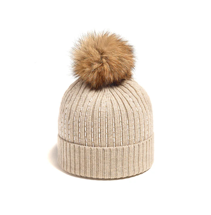 Embrace winter in style with the Rib Mountain Hat, featuring a modern cut and horizontal beading for added sophistication. Made of a viscose, acrylic, and cashmere blend, it offers excellent stretch and a soft feel while keeping you warm. The coyote fur pompom adds a touch of luxury to this must-have accessory.