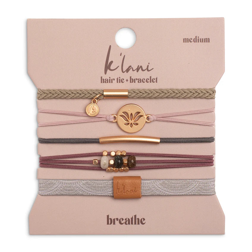 The K'lani Breathe set features five versatile bracelets that also serve as hair ties, designed in calming colors to inspire mindfulness and tranquility. Each piece is adorned with a lotus flower charm and earthy stone beads, offering subtle, yoga-inspired accents that promote a sense of peace and balance throughout your day. Ideal for those seeking both style and serenity in their accessories.
