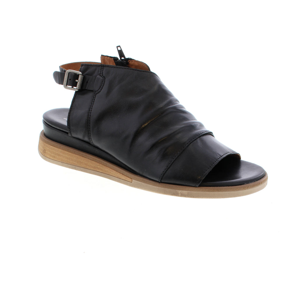 Master the art of effortless style with the Miz Mooz Conor sandal. Featuring simple rouching on the uppers, a slight wedge with wooden detail in the sole, and a functional buckle to keep your foot in place, this sandal is perfect for those who appreciate a minimalist approach to fashion. Its understated design allows for easy styling and pairs well with any outfit. Elevate your summer wardrobe with the classic and timeless Conor sandal.