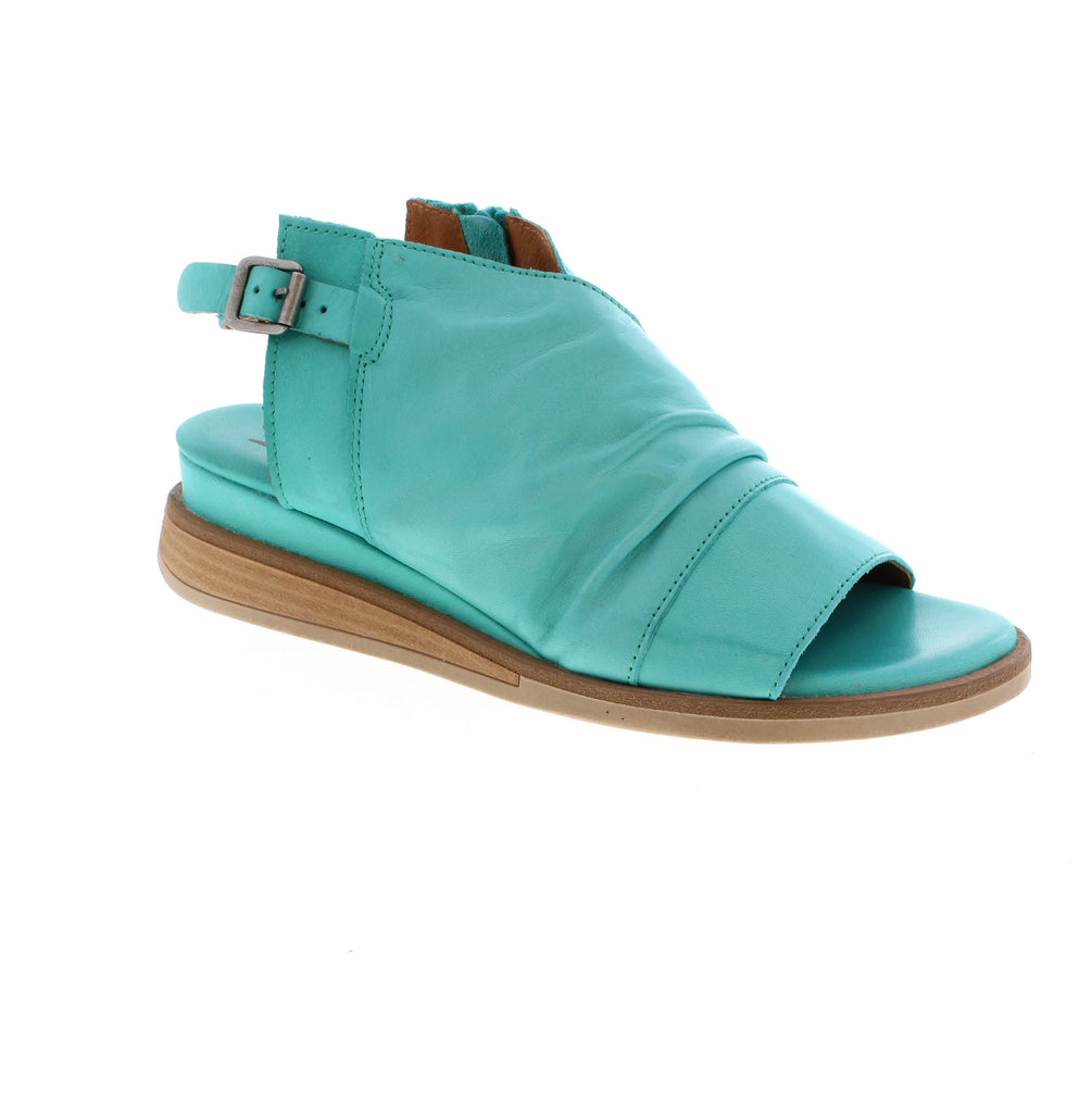 Master the art of effortless style with the Miz Mooz Conor sandal. Featuring simple rouching on the uppers, a slight wedge with wooden detail in the sole, and a functional buckle to keep your foot in place, this sandal is perfect for those who appreciate a minimalist approach to fashion. Its understated design allows for easy styling and pairs well with any outfit. Elevate your summer wardrobe with the classic and timeless Conor sandal.