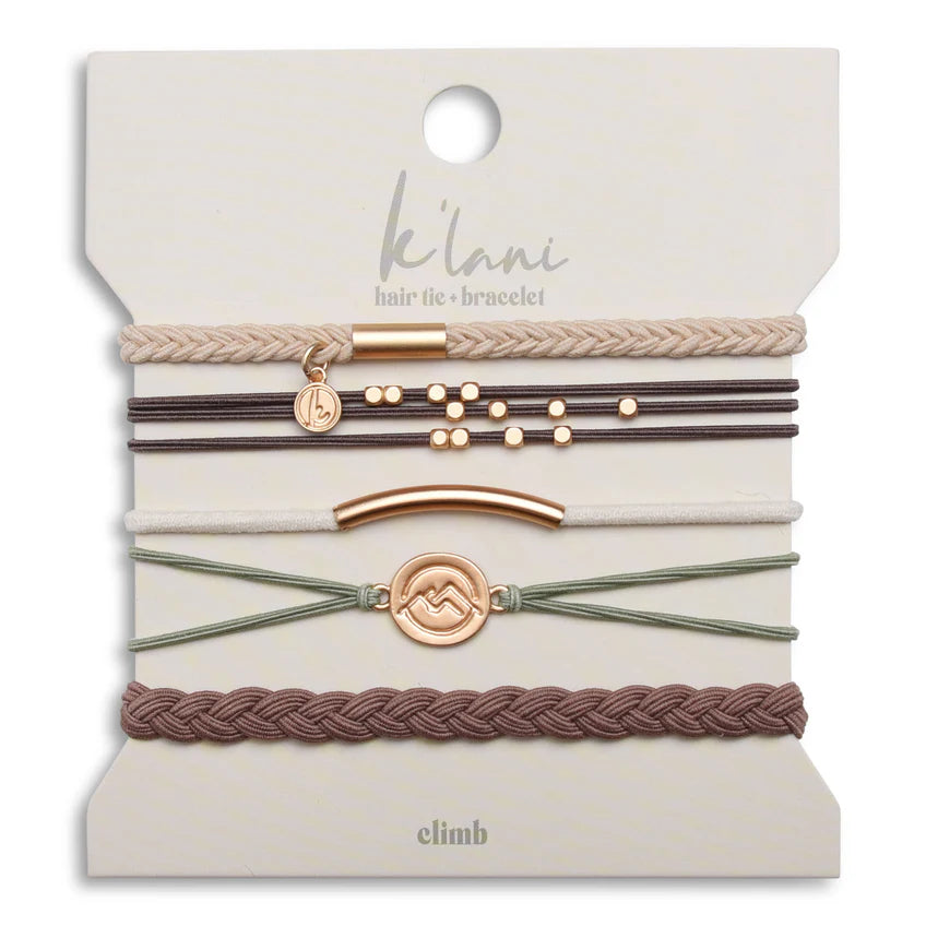 The K'lani Climb set features five versatile bracelets that also serve as hair ties, crafted in warm neutral tones of brown, cream, and green. Each piece is accented with a gold charm depicting mountain peaks, symbolizing the journey toward your personal summit. Designed for both style and function, this set offers a subtle reminder that your highest goals are within reach.
