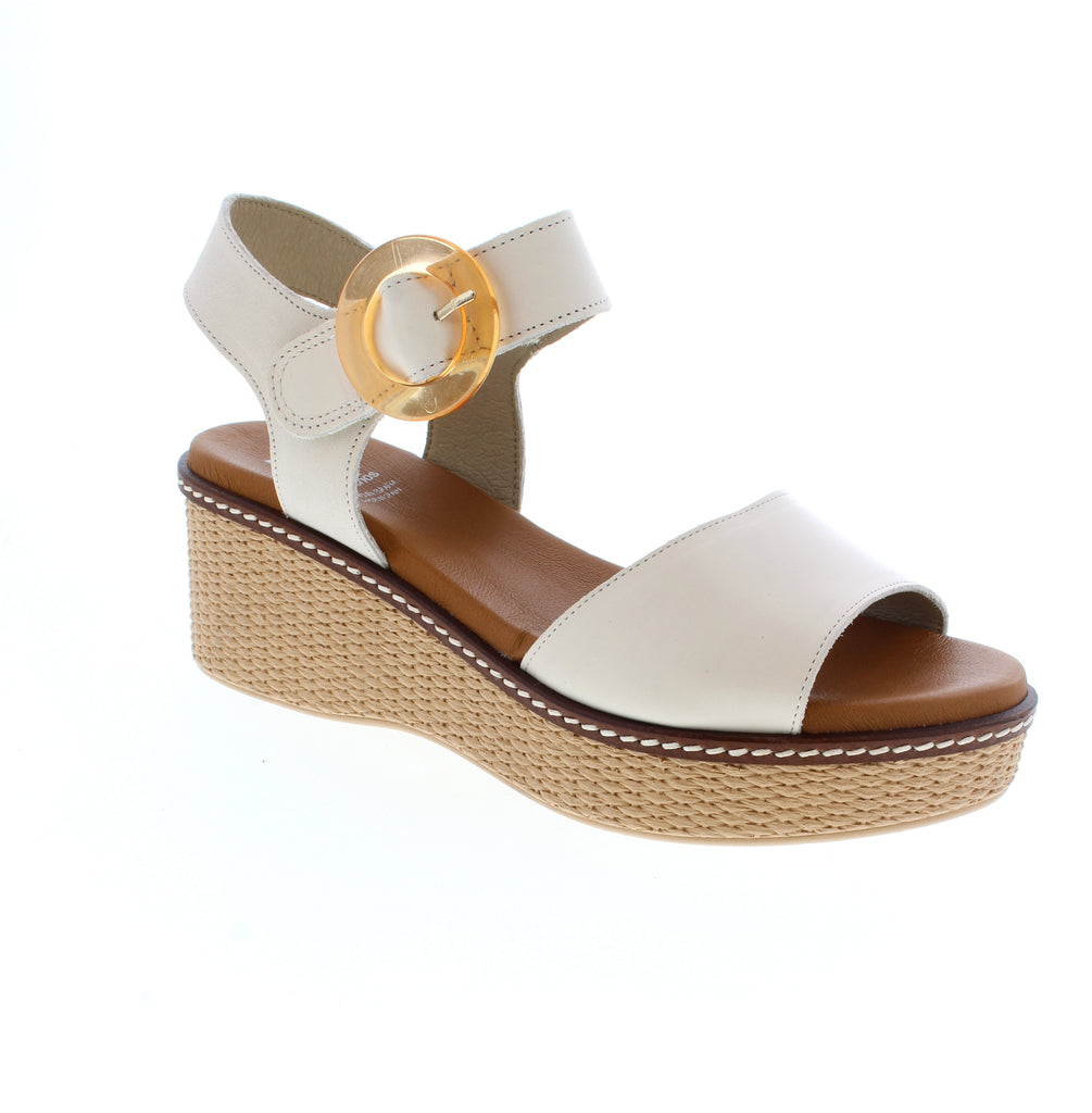 Elevate your summer style with the Dorking Nido D9450 in radiant white. This sandal features a chic wedge platform heel that adds height without sacrificing comfort. Premium leather uppers and footbed pair with a cushioned foam midsole for all-day support, while the halter strap and velcro closure work together to keep your narrow-to-medium foot secure and snug. The round toe and metallic finish add a touch of glamour to any outfit.