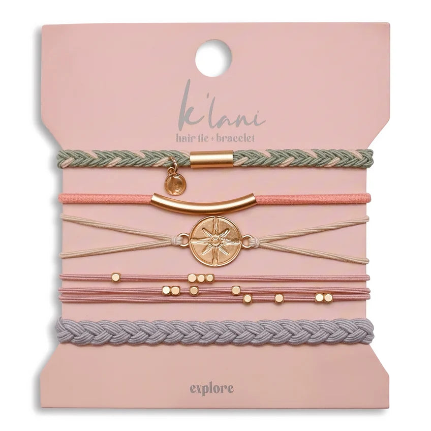 The K'lani Explore set features five versatile bracelets that also serve as hair ties, crafted in a harmonious mix of tan, pink, gray, and green tones. Each piece is accented with a gold compass charm, symbolizing a spirit of adventure and encouraging wearers to embrace exploration in their daily lives. Designed for both style and function, these accessories seamlessly blend practicality with meaningful design.
