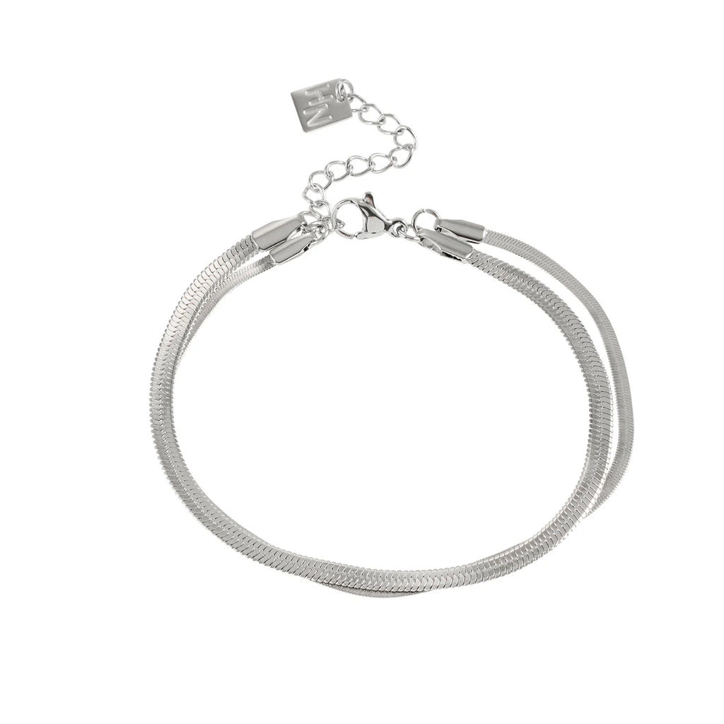 Elevate your everyday look with the Hackney Nine Inese bracelet. This sophisticated two-layer bracelet features contrasting widths and a captivating snake-skin texture that catches the light beautifully. Crafted with 18 karat infused white gold, it delivers luxury without the worry—hypoallergenic, nickel-free, and built to last without tarnishing.