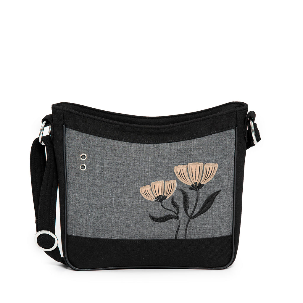 The Jak's Actuelle Cocotier shoulder bag in Sand combines elegance with practical design. Featuring delicate floral appliqué embroidery, it adds a touch of sophistication to any outfit. Its clean lines create a timeless silhouette, perfect for daily use or special occasions. The bag includes a convenient organizer pocket on the back, ideal for storing cards, coins, and personal items securely, keeping essentials within easy reach. 