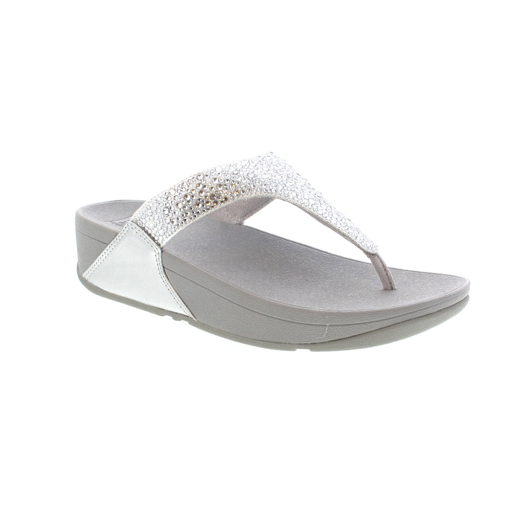Experience style, comfort with the Fitflop Lulu Toe-Post JE3. These shimmering silver sandals feature metallic straps for a minimalist-chic look. With unbeatable comfort and pressure-diffusing Microwobbleboard™ midsoles, these sandals are perfect for any occasion.