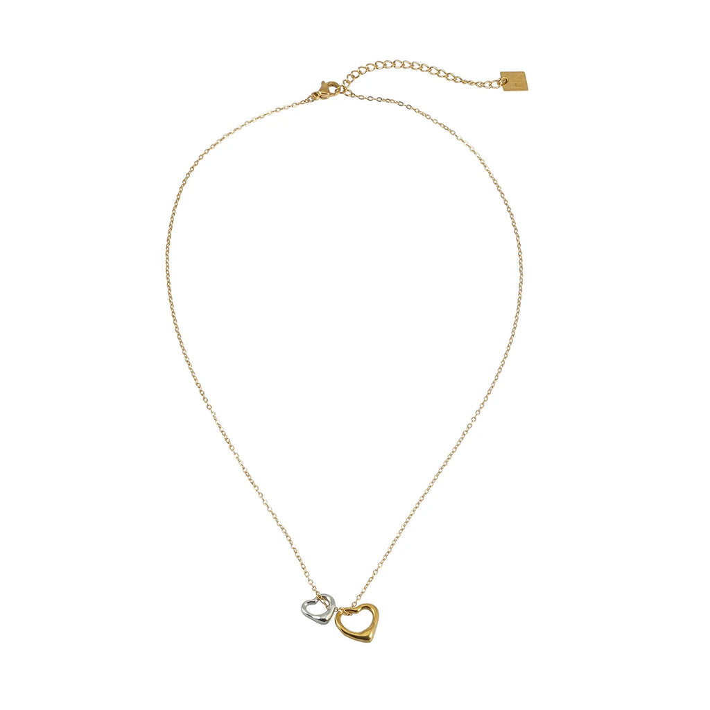 Introducing the Lolanda by Hackney Nine. Softly expressive and effortlessly refined, this delicate gold chain necklace is adorned with two abstract heart-shaped charms—one in warm gold and the other in cool silver. The striking mixed-metal design captures a sense of balance, while its understated silhouette offers a modern yet timeless appeal.