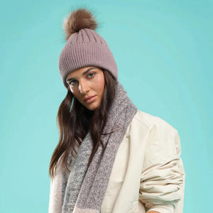 Upgrade your winter wardrobe with the Morgan & Taylor Remi Beanie in Brown. Made from a warm wool-blend, this classic silhouette features ribbed detailing and a cute faux fur pom-pom. Perfect for staying cozy and stylish all winter long.