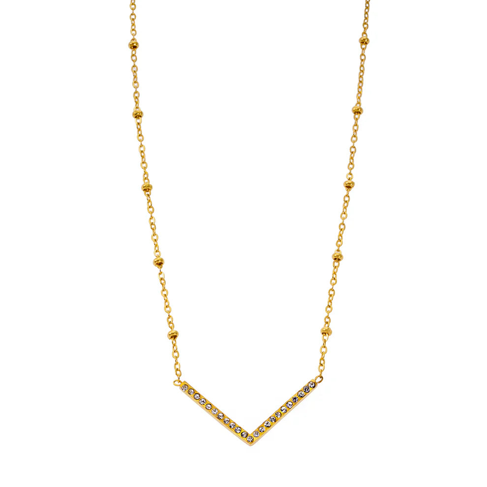 This artisanal Hackney Nine Sanita necklace combines elegance and contemporary design. The 'V' shaped pendant sparkles with zirconia gemstones, while the beads on the dainty chain reflect the light with every movement. Made from premium base metal, this necklace is layered with 18 karat pure gold and silver for a luxurious touch.