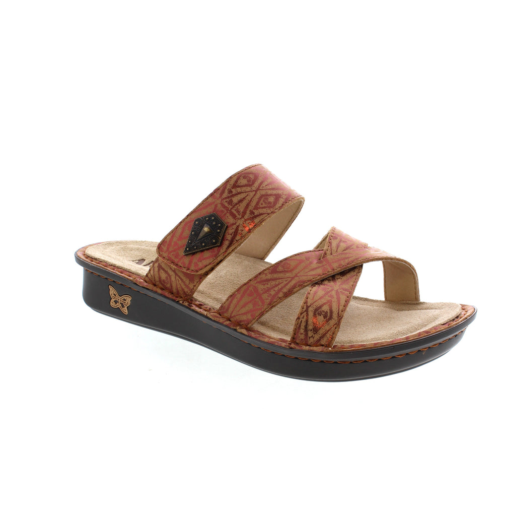 Elevate your summer style with the Alegria Victoriah - Relic (Bronze) slide sandal. Its intricate design, metallic hardware, and adjustable strap add a touch of glamour to any outfit. The slim Mini outsole mimics a natural rocking motion for improved pressure distribution, while the ergonomically designed patented footbed relieves leg, hip, and back strain from long hours on your feet.