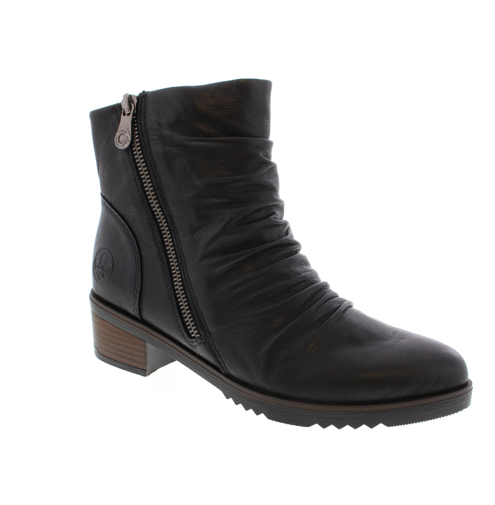 Sophisticated black ankle bootie with a sleek almond toe and practical block heel. Crafted with a supple leather upper, cozy faux fur lining, and cushioned microfiber footbed for all-day comfort.