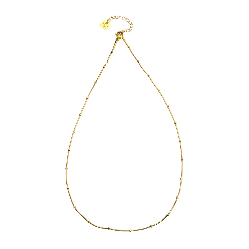 Elevate your style with the Hackney Nine Zahara dainty beaded chain. Crafted from premium-grade base metal and layered in opulent 18 karat gold, this accessory exudes elegance. Adorned with sustainable natural stones and AAA zirconia gemstones, it's perfect for any occasion. Water-resistant and allergy-free, it's a truly luxurious addition to your collection.
