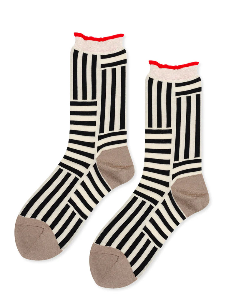 Get ready to be amazed by the Hansel from Basel Illusion socks in black and white! The unique mix-and-match stripes create an optical illusion that will catch everyone's attention. The contrast of the toe, heel, and red-tipped cuff adds even more graphic appeal. Made in Japan with a high needle count and hand-closed toe for ultimate comfort.