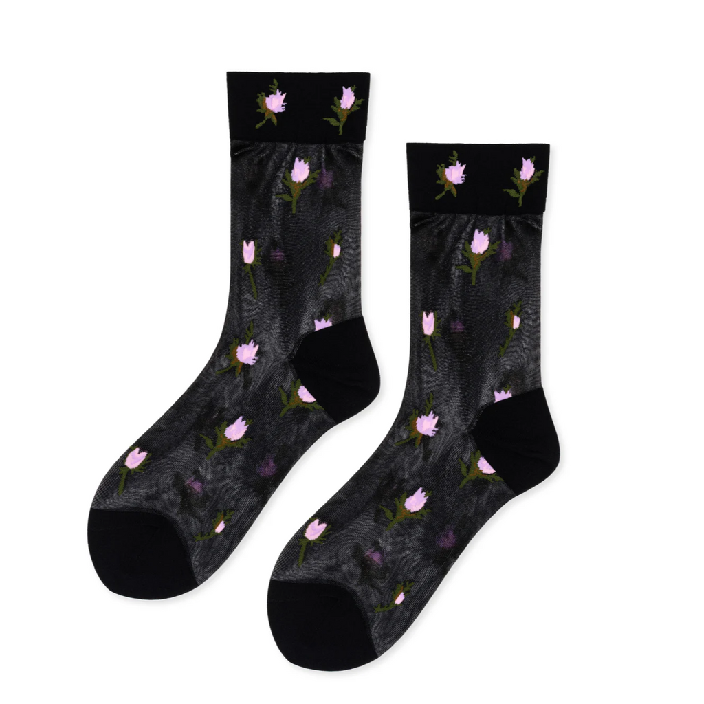 Experience a delicate blend of vintage charm and modern style with the Hansel From Basel Rosebud Sheer Crew Sock in Black. These sheer socks feature a subtle rosebud pattern that adds a touch of sweetness and elegance to any outfit. Inspired by a nostalgic, grandma’s-knitting vibe, they bring a unique softness and grace to your wardrobe. Perfect for pairing with your favorite shoes or wearing as a standout accessory, these socks offer light breathability and a comfortable fit
