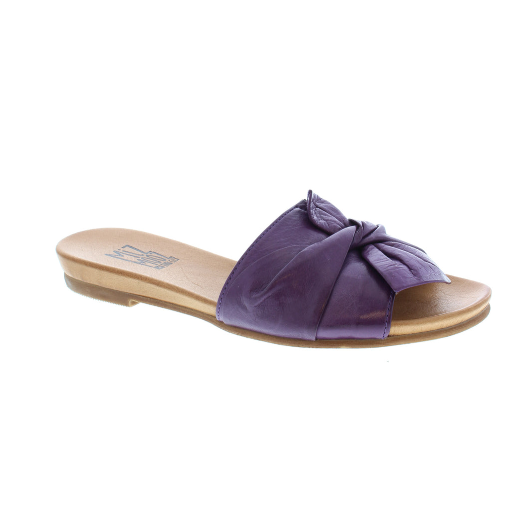 The Angelina is designed with a soft, leather band. A knotted bow on the upper offers a playful twist to this simple slide. The slight heel makes these sandals a pleasant, everyday shoe.